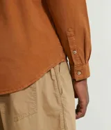 Camisa de manga larga de algodón oxford color marrón, de corte casual, con bolsillos frontales con solapa y cierre de botones.