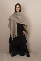 Ruana de lana fina sin teñir, con textura acanalada y terminaciones tejidas a crochet hechas a mano.