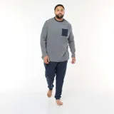 Conjunto de pijama de dos piezas compuesto por una camiseta de manga larga a rayas horizontales finas con bolsillo frontal y un pantalón largo de color azul marino con puños elásticos en los tobillos.