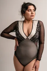 Body negro de manga larga confeccionado en lycra, microtul y puntilla. Escote en V y parte delantera forrada en lycra color crudo.