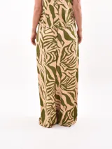 Pantalón palazzo estampado con motivos de hojas en tonos beige y verde.