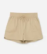 Short color beige de sarga de algodón, con cintura elástica, lazo ajustable y bolsillos laterales. Corte holgado.