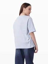 Remera celeste de algodón con cuello redondo y mangas cortas con puños negros. Estampado frontal con el logo de Tommy Hilfiger en color crema.