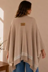 Ruana gris de tejido de algodón, con diseño abierto y detalle de franja calada en el borde inferior.