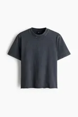 Remera de algodón con efecto lavado, color gris oscuro, corte regular fit, mangas cortas, hombros caídos, cuello redondo acanalado y bajo sin rematar.