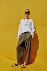 Pantalón de lino marrón oscuro, de corte barrel con pernera holgada que se estrecha hacia el tobillo, cintura elástica y bolsillos delanteros.