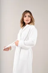Bata de polar color blanco con textura labrada, corte clásico, cuello tipo chal y lazo para ajustar en la cintura.