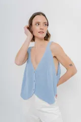 Chaleco celeste de punto con escote en V y cierre frontal con botones. Tejido calado y corte holgado.