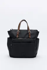 Mochila negra de poliéster texturizado con superficie acanalada. Cuenta con asas superiores marrones, tiras regulables para la espalda, bolsillo frontal con cierre metálico, compartimentos laterales y un interior amplio.