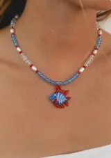 Collar de cristales facetados, cuentas rojas, perlas de río y dije central con forma de pez en cristal de murano de colores azul, blanco y rojo.