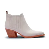 Bota texana de caña corta en color beige, con diseño de elásticos laterales, taco cuadrado de madera y puntera metálica decorativa.