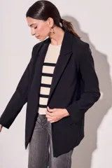 Blazer negro de corte clásico con solapas y mangas largas con puños con rayas verticales.