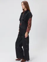 Campera de denim a rayas verticales con cuello de pana en color bordó. Presenta cierre frontal, mangas desmontables con cierre en los hombros, canesú en el pecho y bolsillos de parche cuadrados.