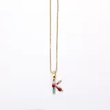 Collar dorado con dije de la letra K, adornado con cristales de colores.