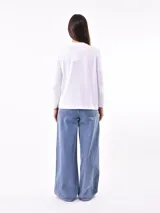 Remera de manga larga color beige, con cuello redondo y estampado frontal que dice "Magic is something you make" en color lila.