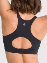Top deportivo de soporte alto en color negro, con tirantes ajustables y cierre de ganchos en la espalda. Cuenta con almohadillas removibles y diseño con apertura en la espalda para mayor ventilación.