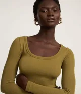 Top corto de manga larga, color blanco hueso, con escote redondo profundo y tejido acanalado.