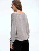 Cardigan de punto con hilo brillante, cuello en V y cierre frontal con botones. Presenta mangas largas con puños acanalados y un diseño de calce holgado.