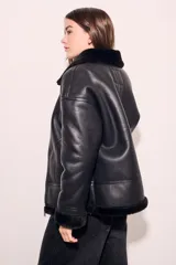 Campera gamulan negra con cuello, puños y ruedo de piel sintética.