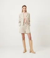 Short de tiro alto confeccionado en tejido tweed con estampado pied-de-poule. Presenta una cinturilla ancha con trabillas y un corte estructurado de estilo sastrero.