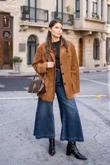 Blazer de corte oversize en color marrón, con diseño estructurado, cuello clásico, cierre frontal de tres botones y bolsillos laterales con solapa.