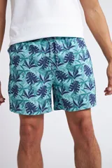 Short de baño con cintura elástica y cordón ajustable, confeccionado en tela ligera de secado rápido. Presenta un estampado botánico integral en tonos amarillos, blancos y azules, con dos bolsillos delanteros y uno posterior.