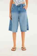 Bermuda de denim color celeste, de tiro medio, con diseño amplio estilo jorts y bolsillos laterales de estilo cargo.