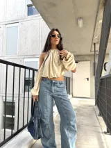 Pantalón de jean celeste con diseño de pinzas frontales y pernera amplia.