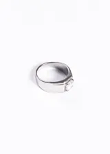 Anillo de acero quirúrgico con diseño de banda ancha y piedra central de zirconia engastada.