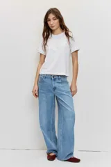 Pantalón de jean de corte regular y pierna ancha, en color celeste con lavado clásico, tiro medio y diseño de cinco bolsillos.
