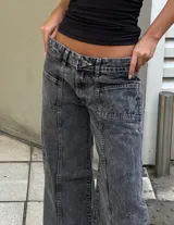 Pantalón de jean tipo wide leg con tiro bajo y lavado acid wash en tono gris oscuro. Presenta costuras verticales decorativas en el frente y bolsillos laterales.