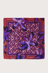 Pañuelo cuadrado de acabado sedoso con estampado que combina motivos florales en tonos violetas y patrones geométricos en marrón y bordó. Presenta el logo de la marca estampado en los bordes.