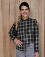 Camisa de manga larga con estampado a cuadros en tonos verde oscuro y beige. Presenta cuello alto con volados, cierre frontal con botones y puños con volados elásticos.