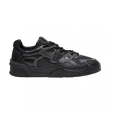 Championes Lacoste modelo Court LT, de diseño urbano en color negro. Presentan una estructura robusta con paneles de cuero y material sintético, cierre de cordones, suela de goma resistente y el icónico logo del cocodrilo en el lateral.