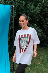 Remerón de algodón blanco con corte oversize y cuello redondo, que presenta un estampado frontal con diseño de una lata de sardinas sobre fondo de rayas.