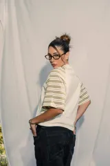 Remera unisex de jersey color blanco con mangas raglán a rayas horizontales en tonos verde oliva y blanco. Presenta un pequeño bordado en el pecho.