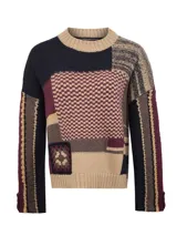 Sweater de lana con diseño patchwork que combina diversos patrones de tejido y bloques de color en tonos tierra, bordó y azul marino. Presenta cuello redondo, mangas largas y terminaciones en rib.