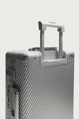 Maleta de cabina rígida fabricada en aluminio con diseño de líneas diagonales en relieve. Cuenta con cuatro ruedas giratorias, cierre TSA, compartimento principal con separador y asa telescópica.