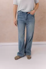 Pantalón de jean azul claro, con tiro medio-alto, corte wide leg y diseño de cinco bolsillos.