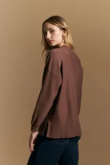 Polera de tejido de punto color marrón, con cuello alto y diseño de líneas verticales en el frente que aportan estructura. Presenta un calce relajado y mangas largas con puños ajustados.
