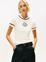 Remera Tommy Hilfiger de corte slim, color blanco, con diseño ringer de cuello redondo y puños en contraste azul marino. Presenta bordado frontal con el nombre de la marca.