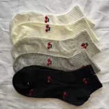 Pack de cinco pares de medias con estampado de cerezas, en colores blanco, amarillo claro, gris claro, gris y negro.