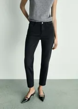 Jeans de corte mom-fit con tiro alto, confeccionados en tejido de algodón con un toque de elastano. Presentan cierre de cremallera y botón, trabillas para cinturón y diseño clásico de cinco bolsillos.