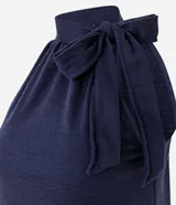 Blusa sin mangas color azul marino, con cuello alto y detalle de lazo integrado en el escote.