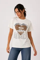Remera de algodón color blanco off-white, de manga corta, cuello redondo a la base y corte holgado. Presenta un estampado frontal con diseño de corazón en tonos marrones y azules, con detalles de strass y texto.