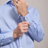 Camisa negra de algodón con cuello clásico, manga larga y cierre frontal con botones. Presenta un logo bordado en el pecho. Corte entallado.