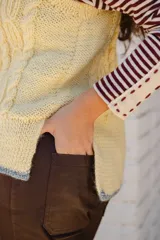 Chaleco tejido de punto con diseño de ochos, cuello redondo y sisa profunda. Presenta un detalle de terminación en color contrastante en el ruedo.