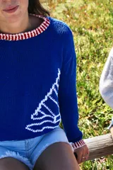 Sweater tejido a mano en lana merino o hilo de algodón, con cuello redondo y diseño de velero en el frente.