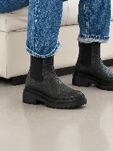 Bota estilo Chelsea de cuero con textura craquelada, cuenta con paneles elásticos laterales y suela de plataforma dentada.