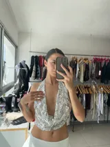 Top halter blanco con lentejuelas plateadas, espalda descubierta y corte crop.